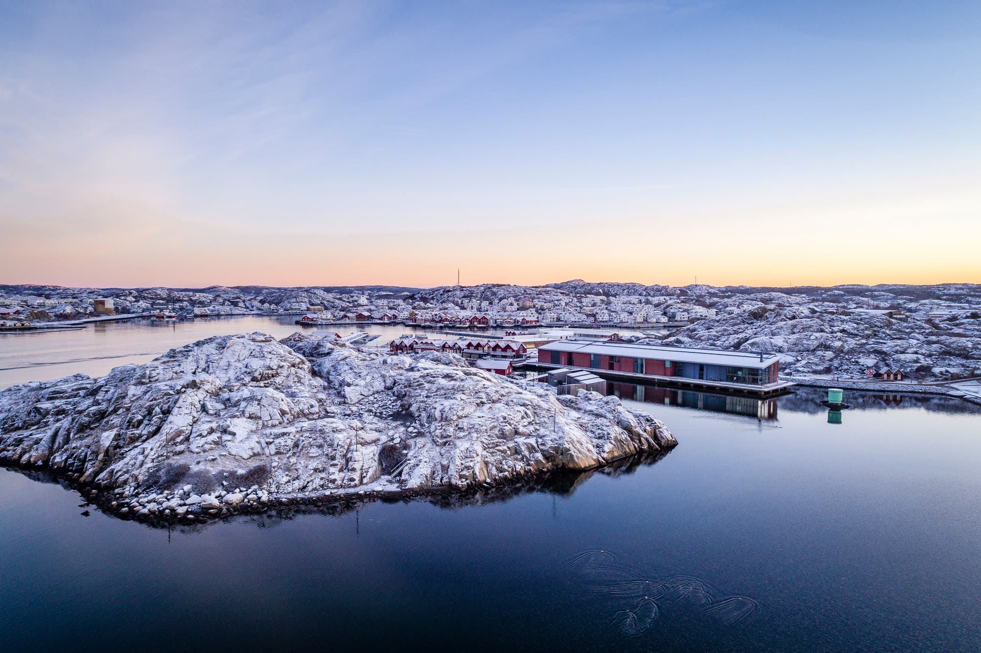 Foto av museet och klipporna klädda i snö, taget med en drönare från havet