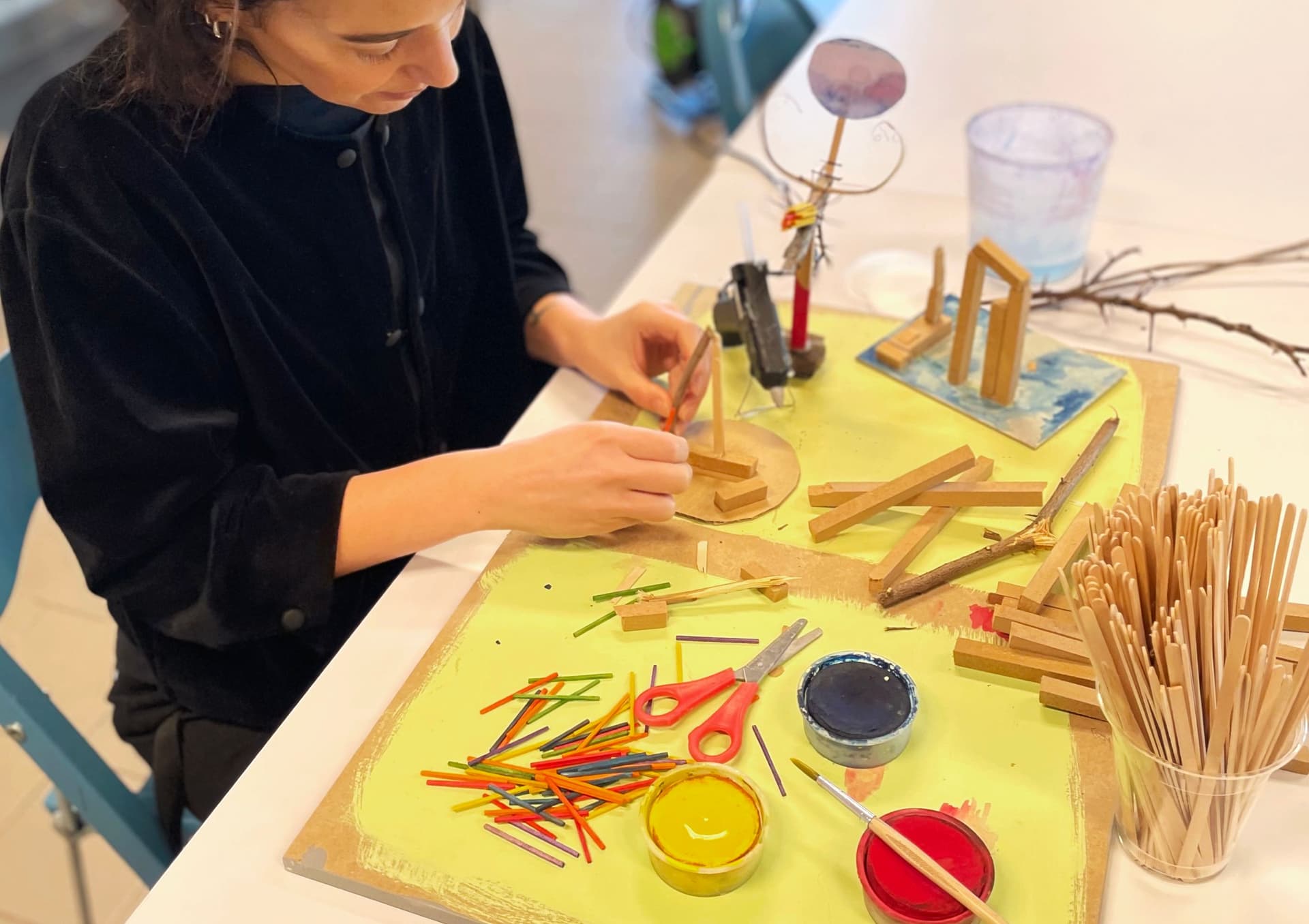 En person som skapar en liten skulptur av träbitar