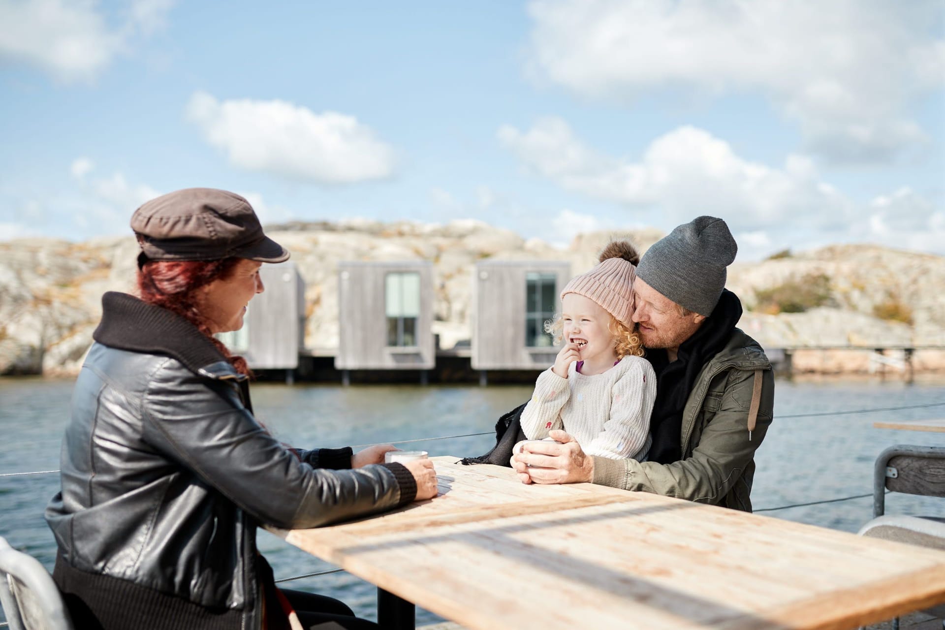 Happy family at outdoor café in autumn clothes