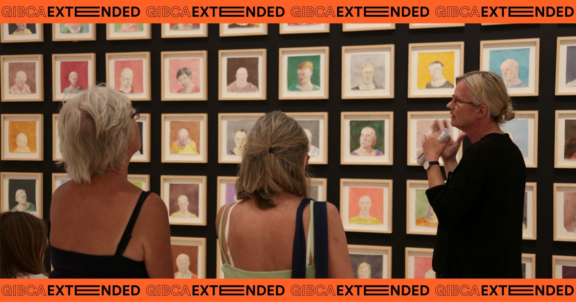 People talking in front of works by Michael Kvium