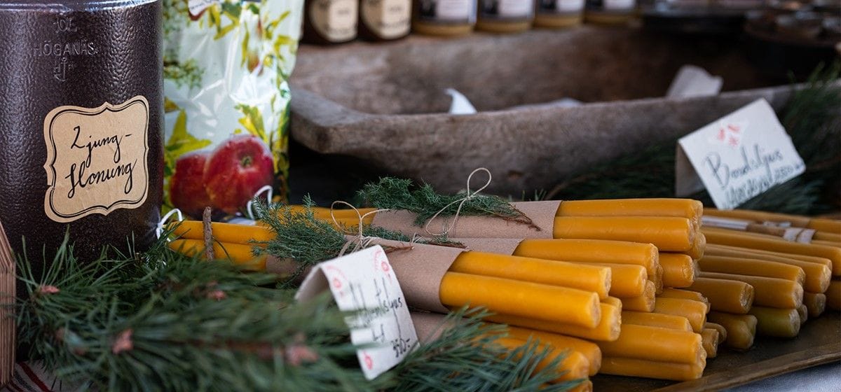 Image of table with yellow candles and honey jars