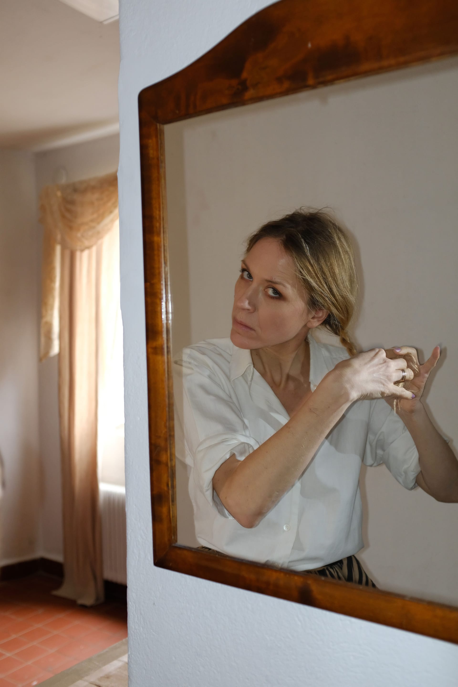 Foto av Frida Hyvönen som tittar i spegeln
