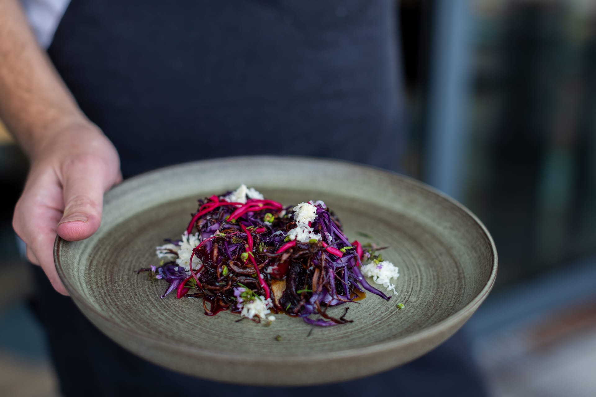 A plate of food held by a hand