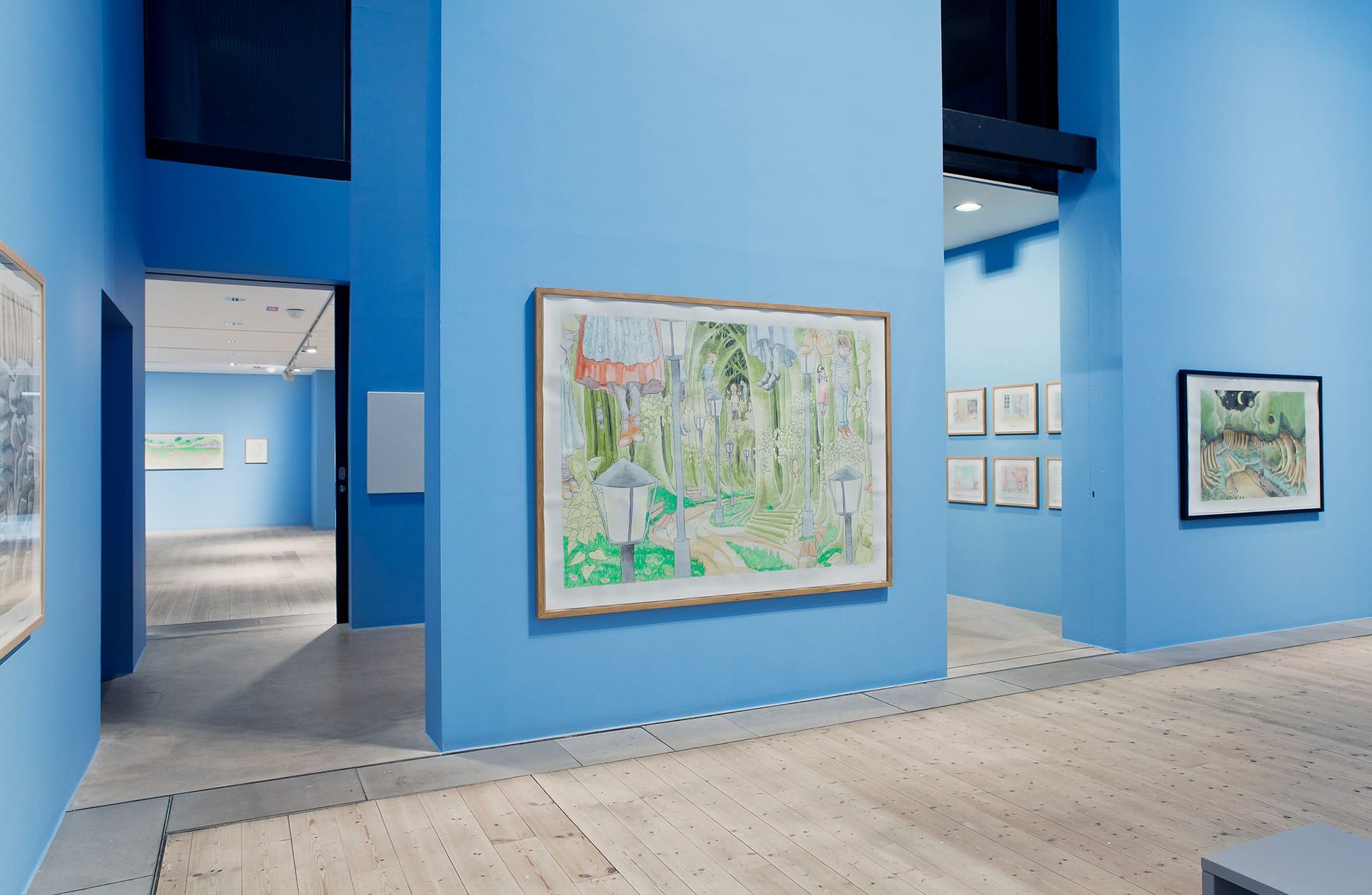 Light blue exhibition room with paintings.