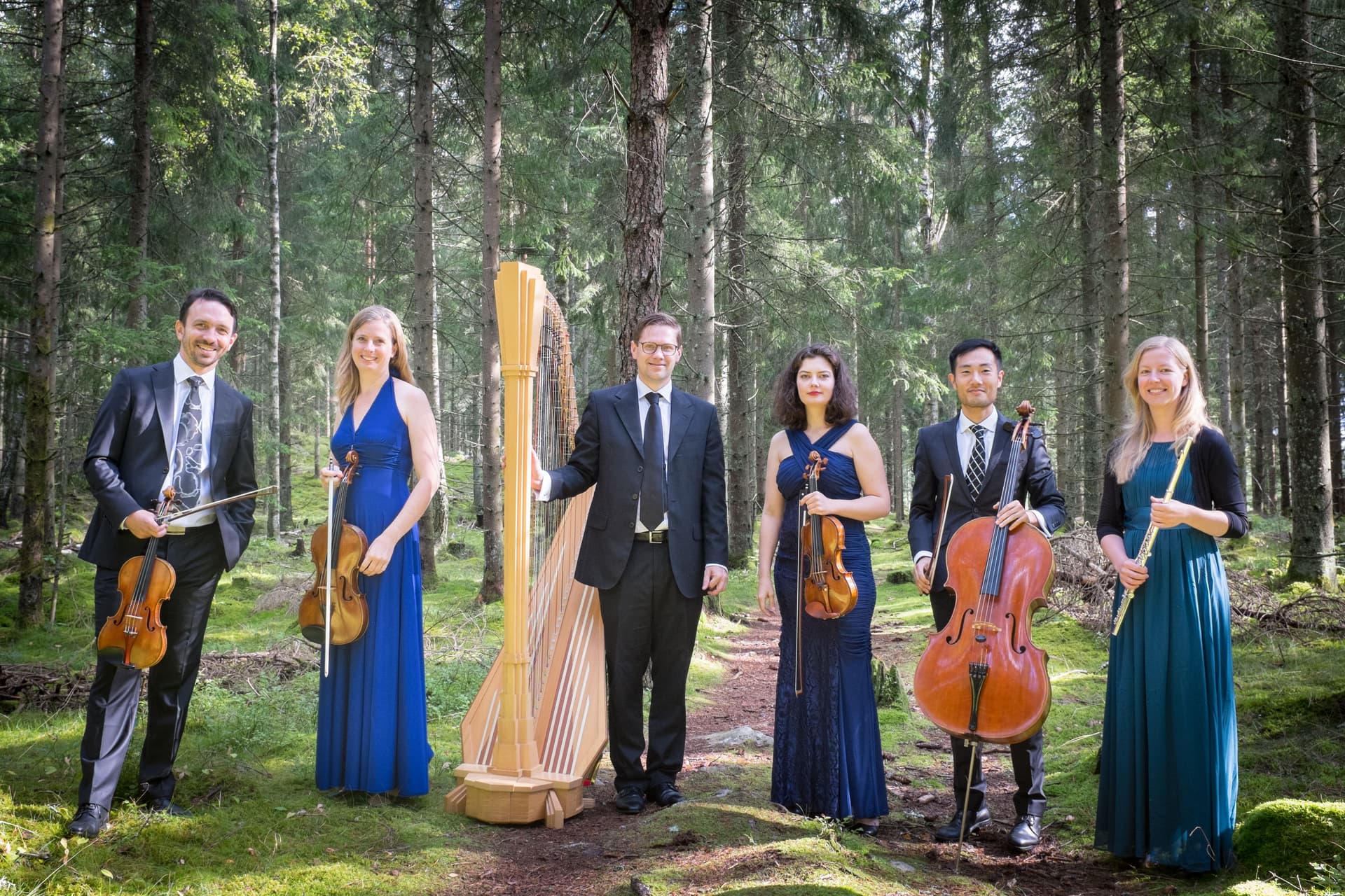 Bild på sex musiker ur Ensemble Cáplet i skogen