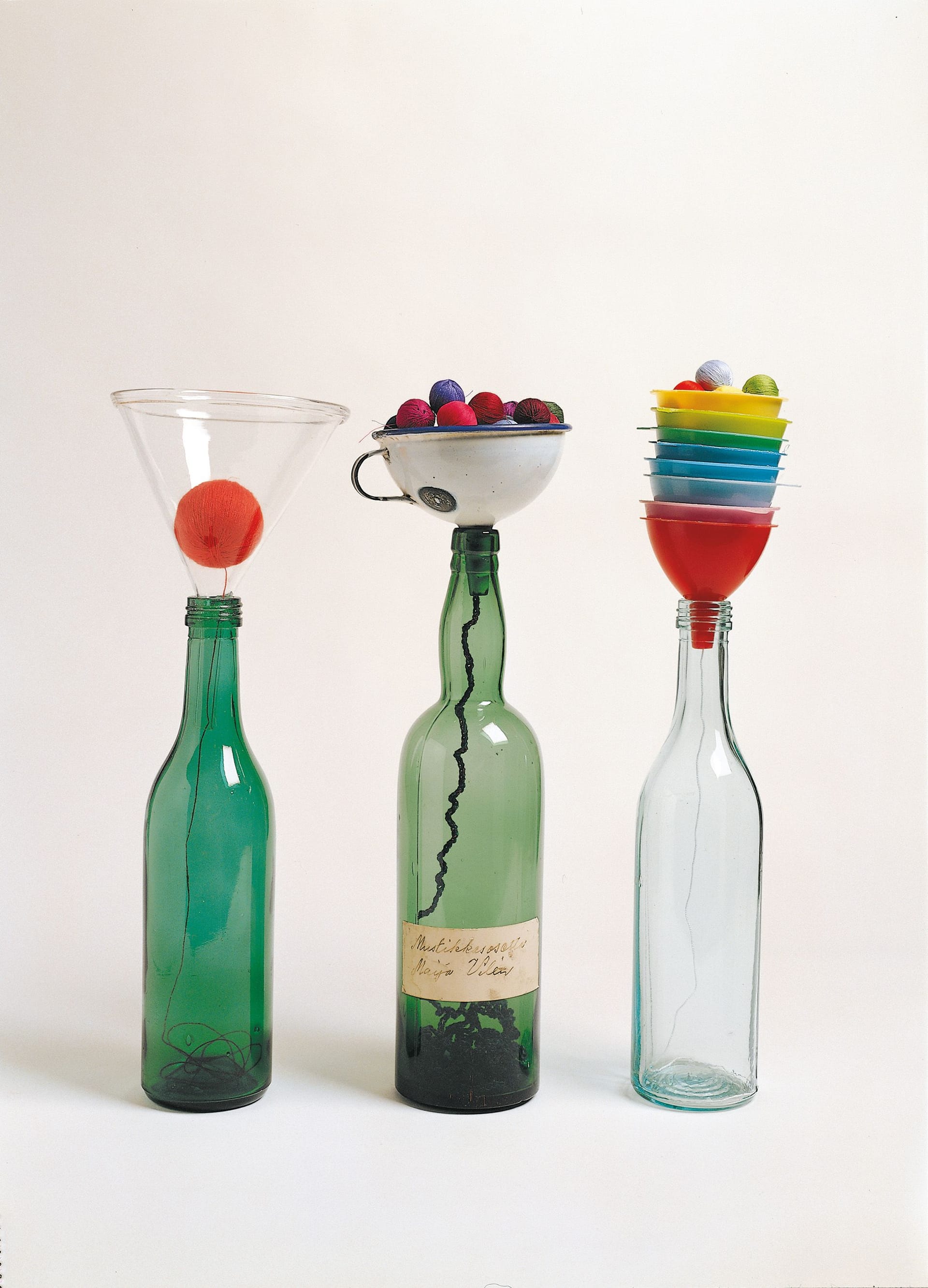 Three bottles with objects in them, work by Anu Tuominen