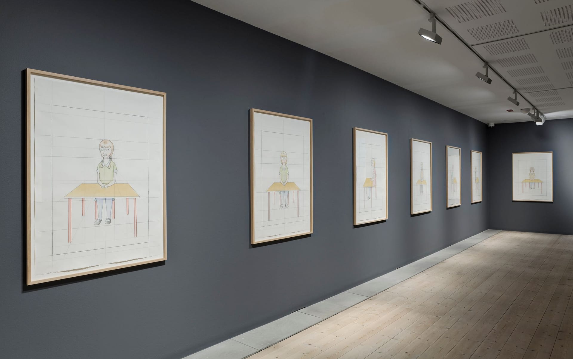 Gray walls with a row of paintings.