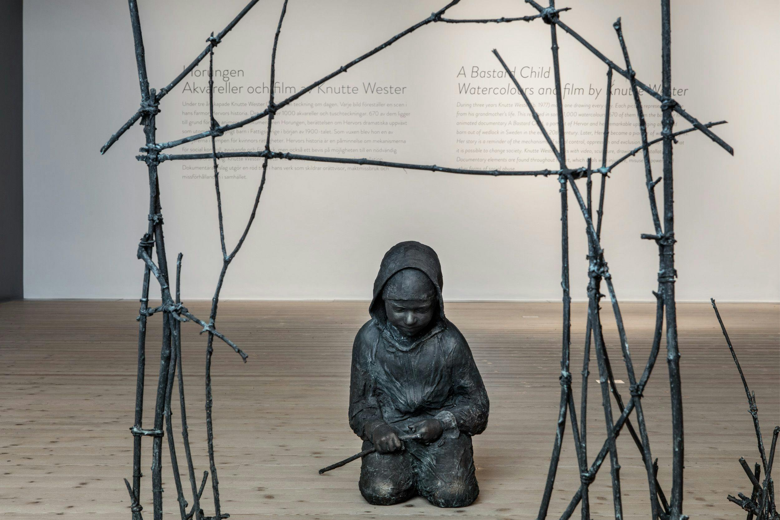 Skulptur av barn under koja byggd av pinna