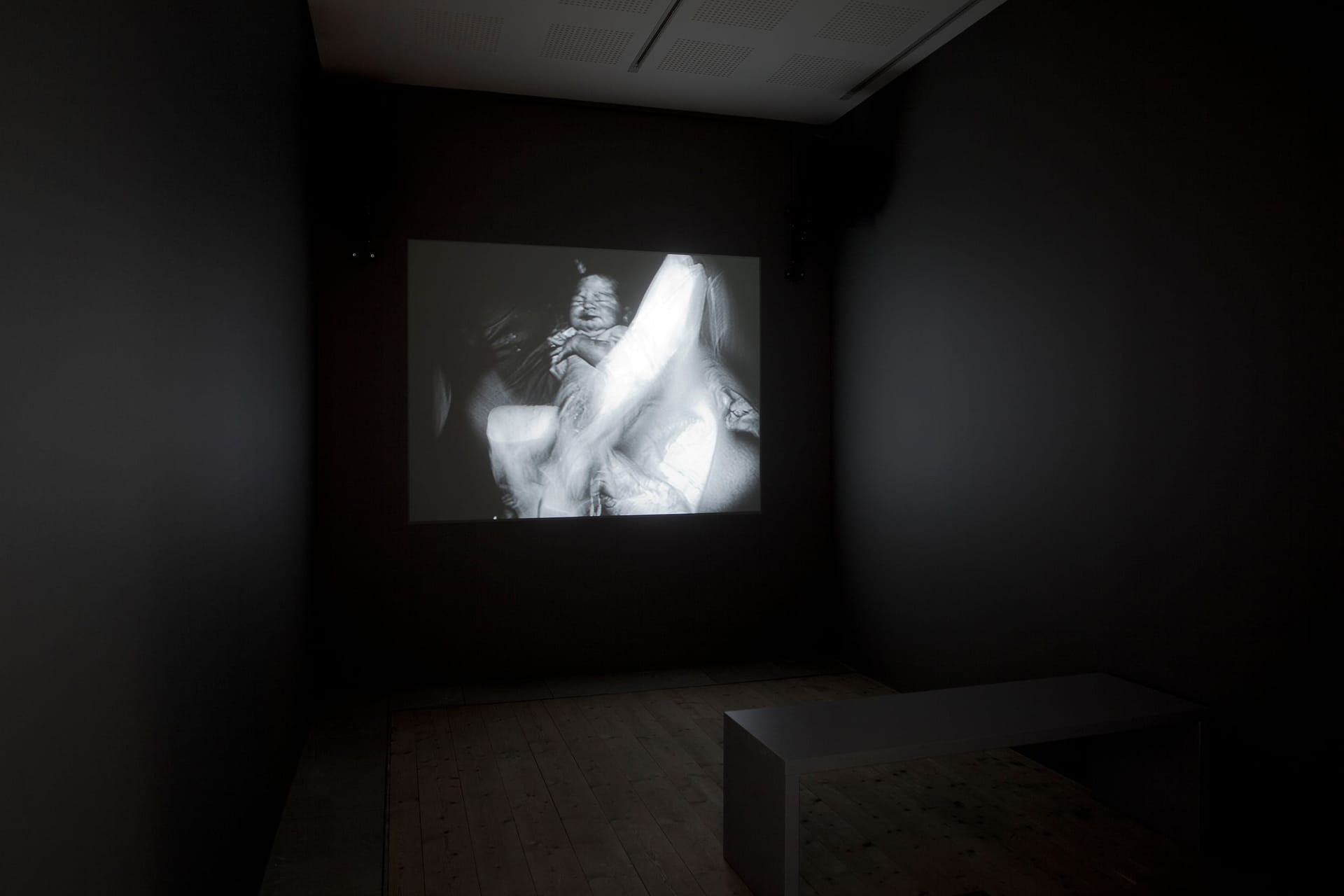 Dark exhibition room with black-and-white video works.