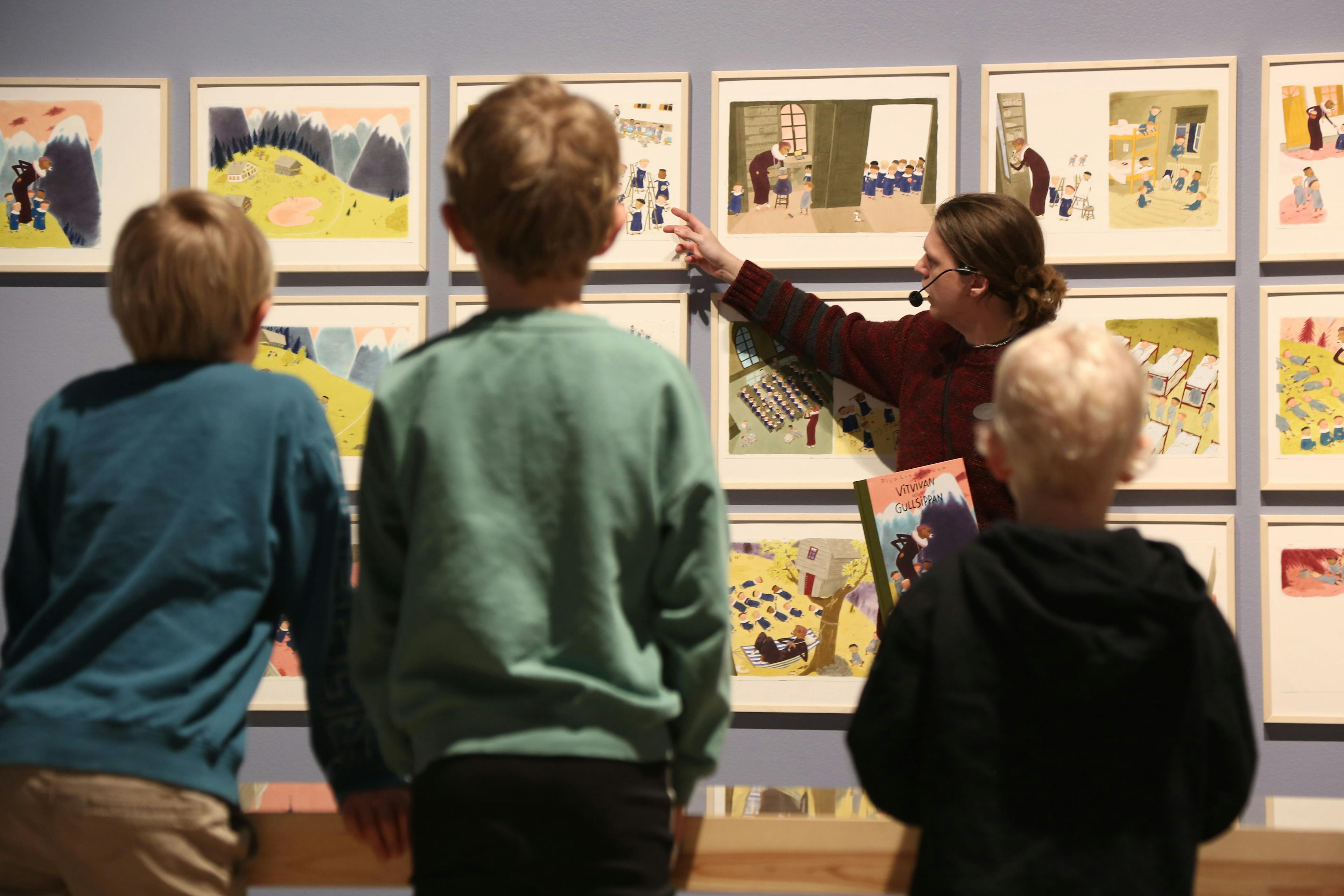 Guided tour, educator in front of children looking at pictures