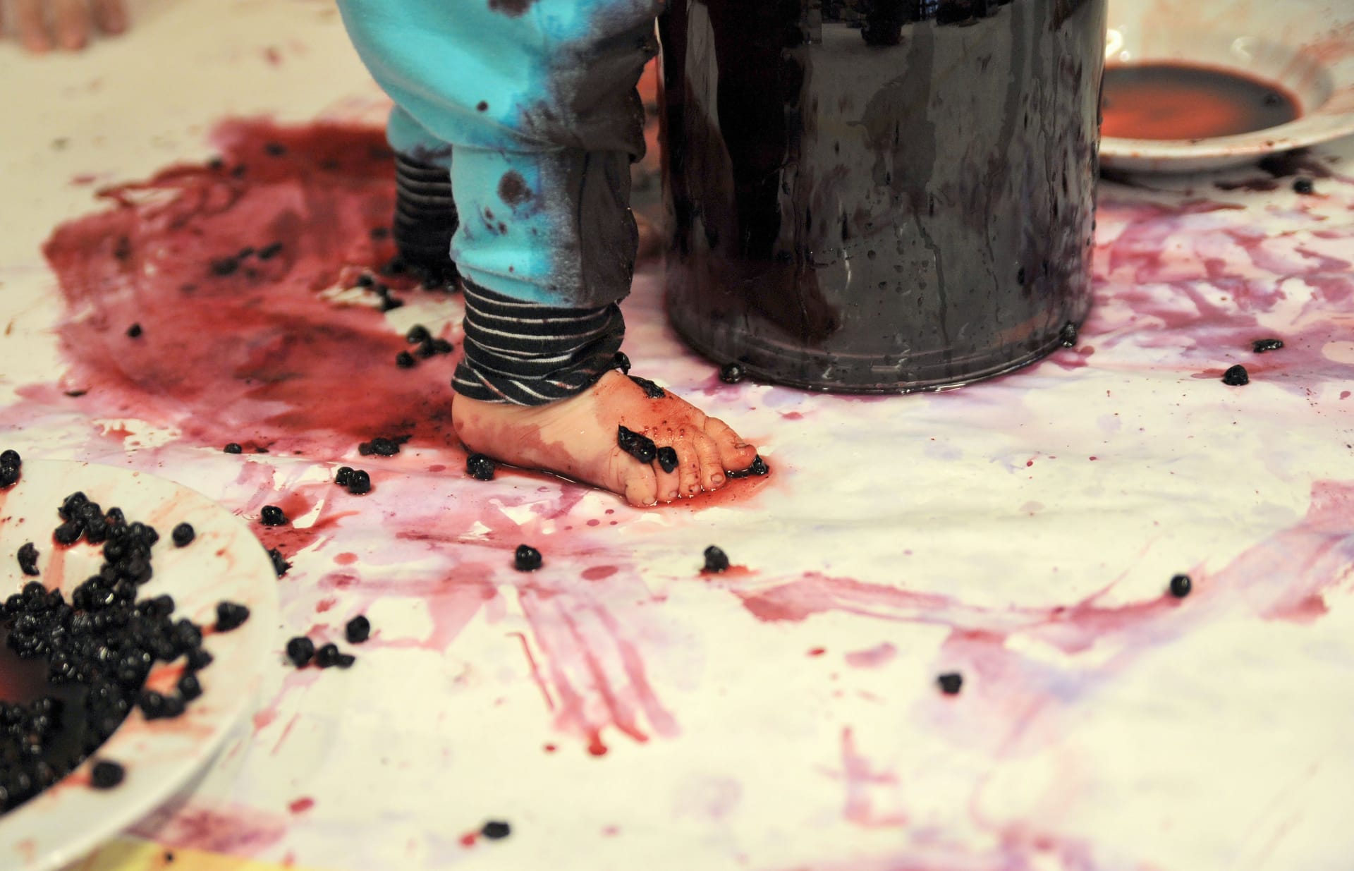 A photo of a pair of baby feet covered in blueberries