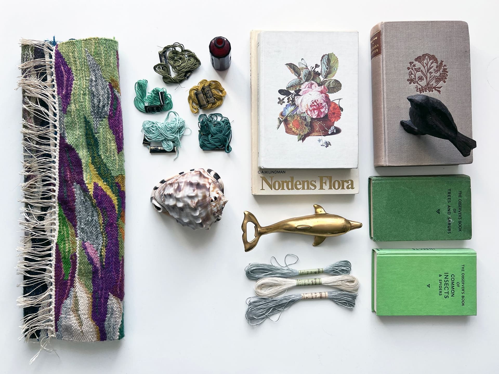 Ett stilleben med skilda objekt, som böcker, figuriner, växter.