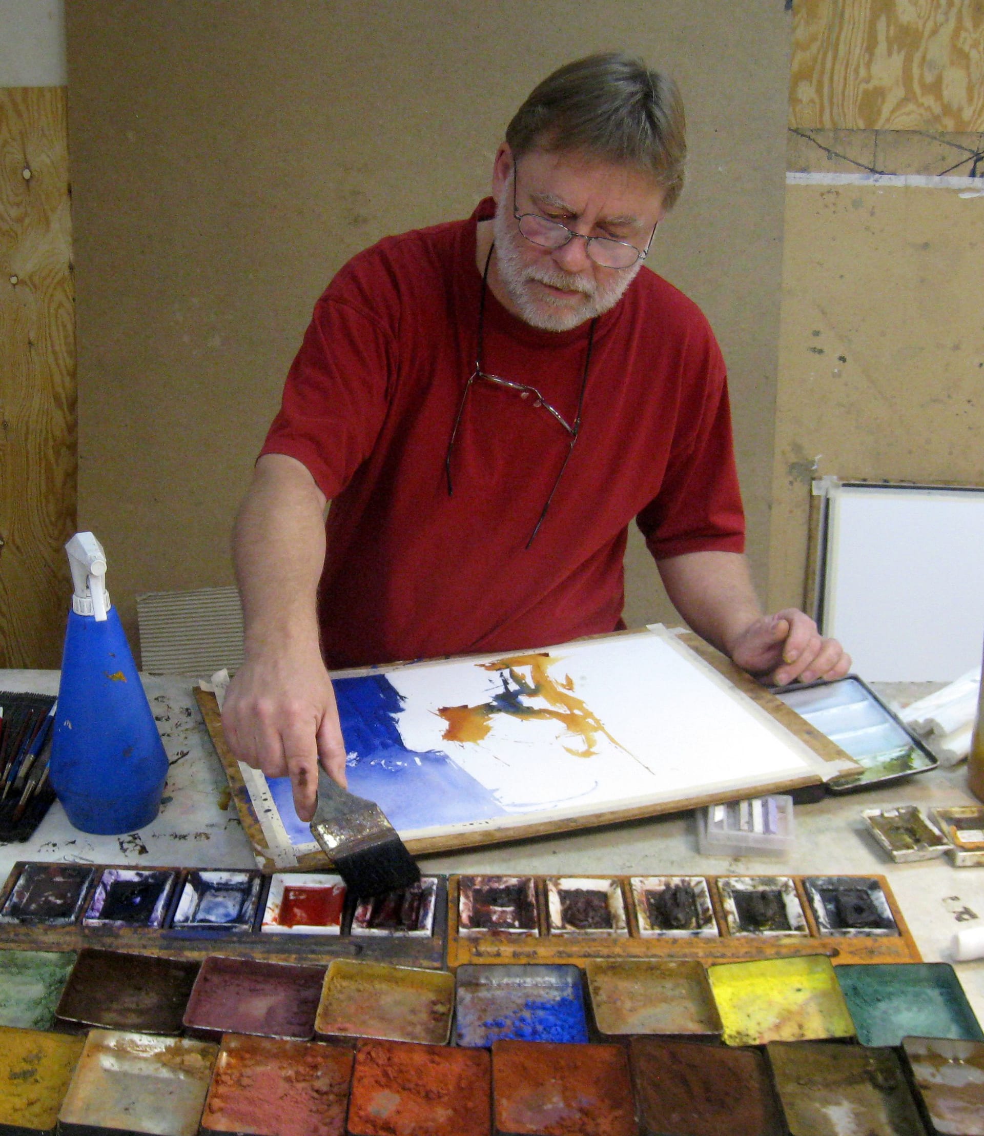 Lars Eje Larsson paints with material in front of him