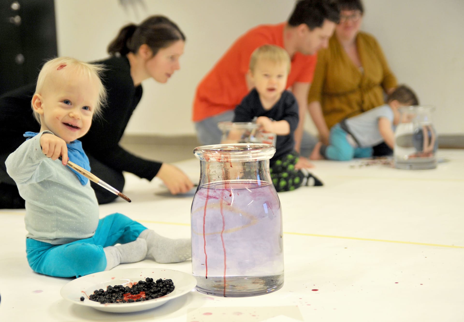 Laughing baby covered in blueberries