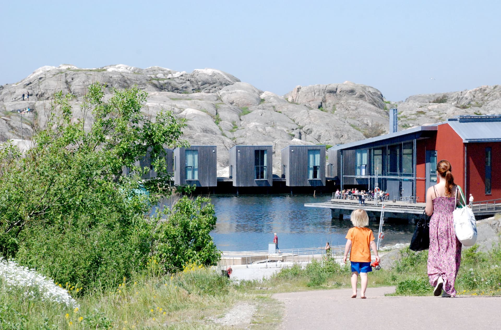 Barn och vuxen promenerar mot museet i solen