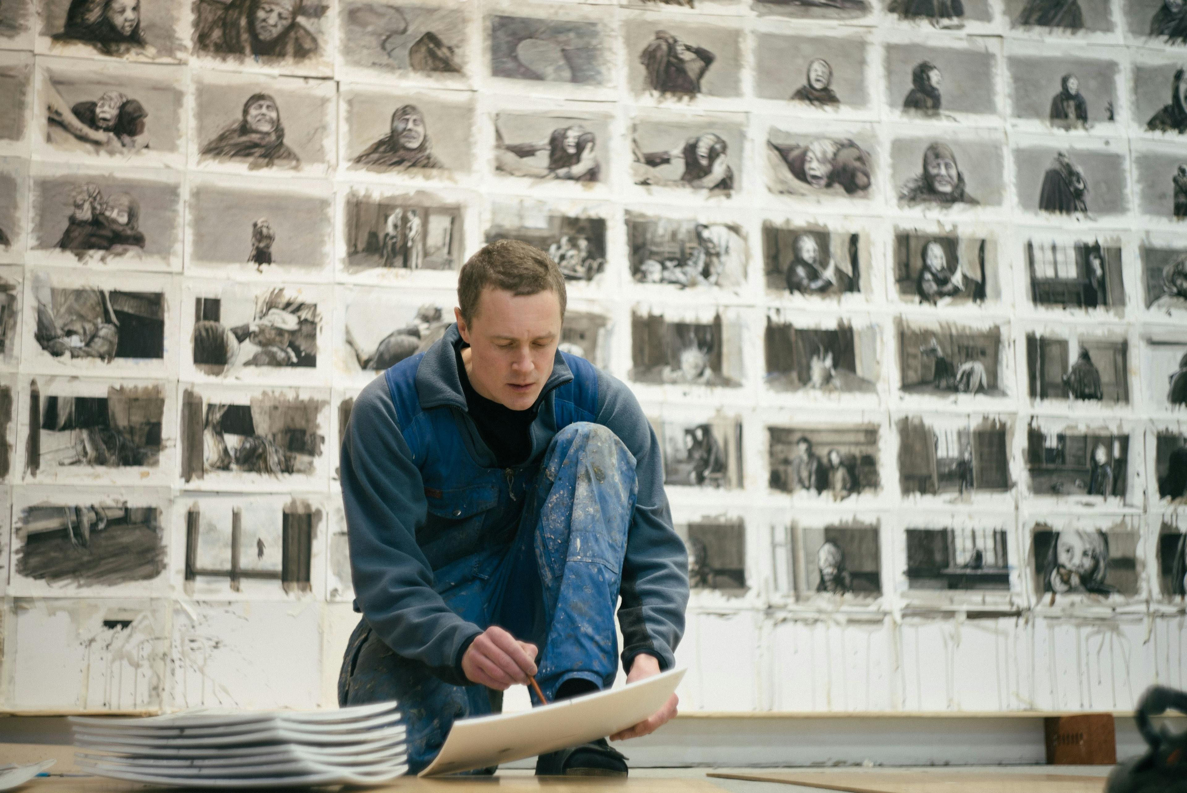 Bild av Knutte Wester på knä i sin ateljé