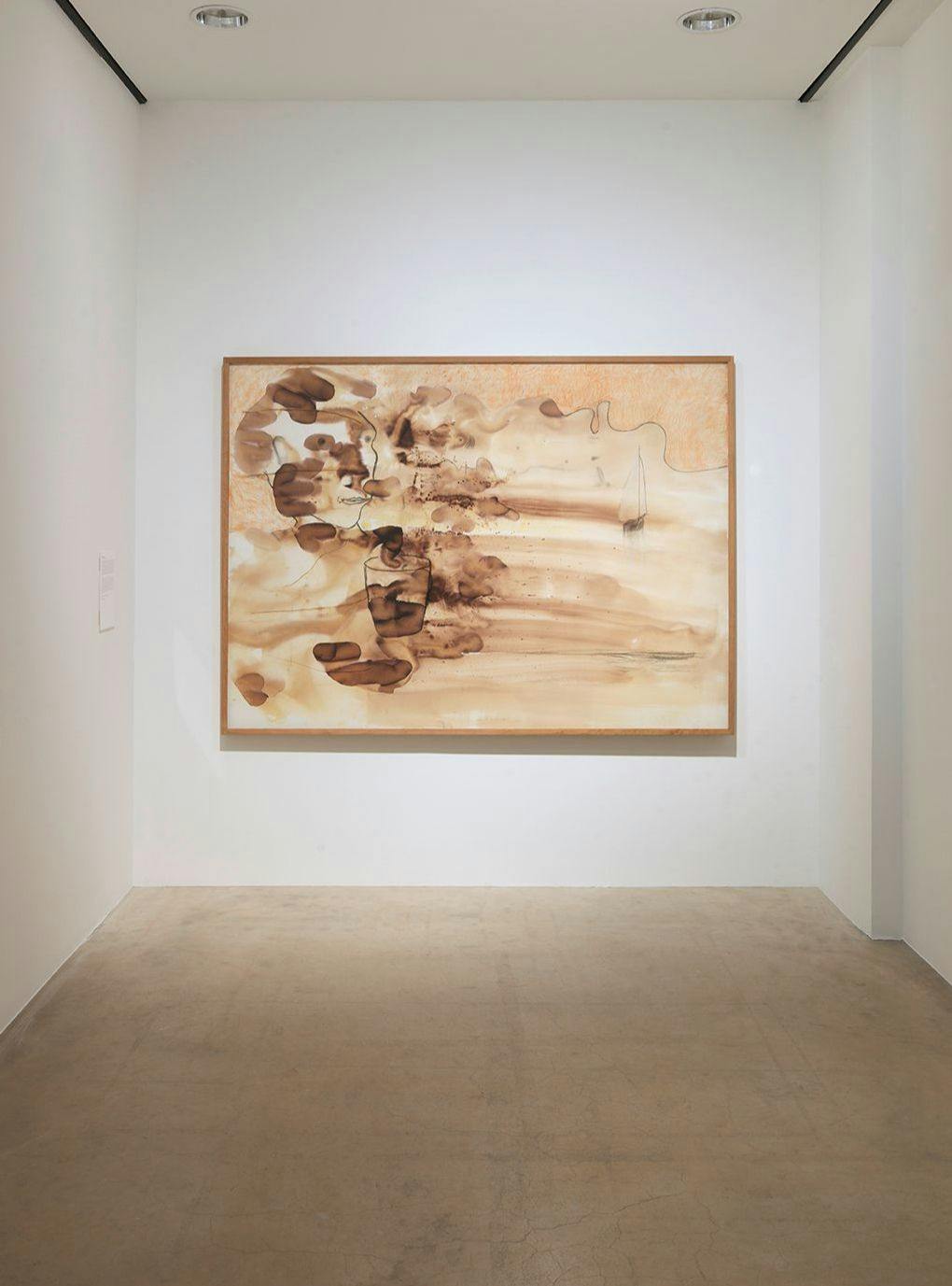 Verk i bruna toner av Erik Dietman i utställningen, mot vit vägg
