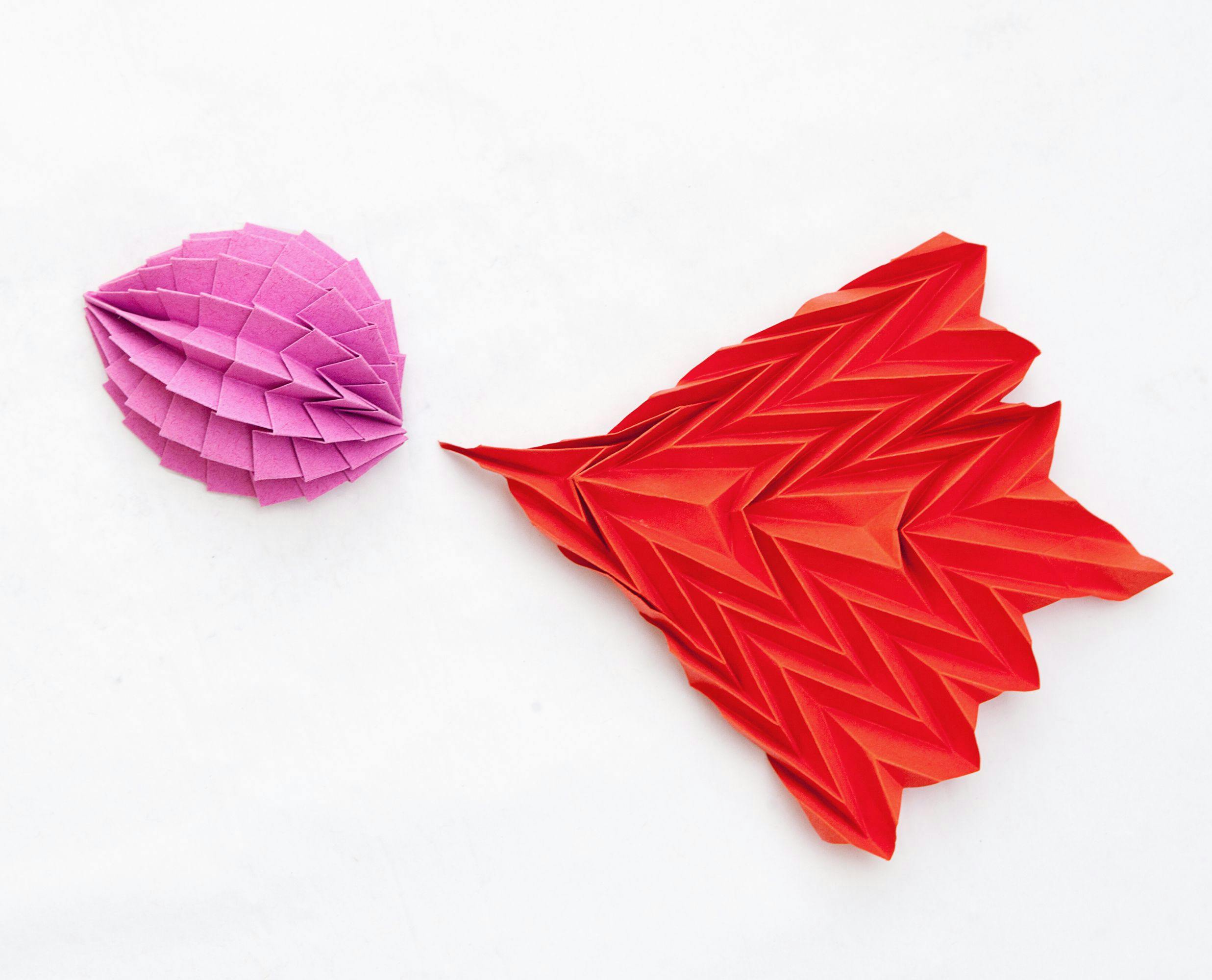 Två geometriska origami i rosa och rött