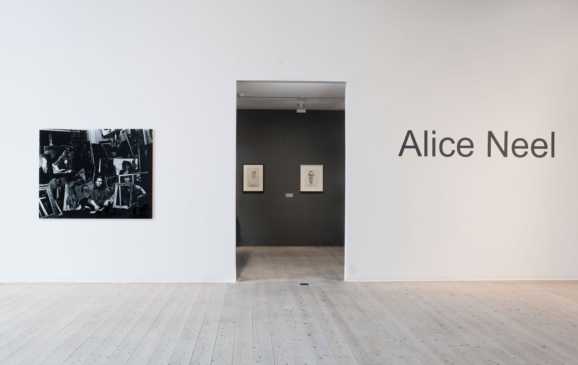 White wall with black and white photo of Alice Neel on the left and the text "Alice Neel" on the right
