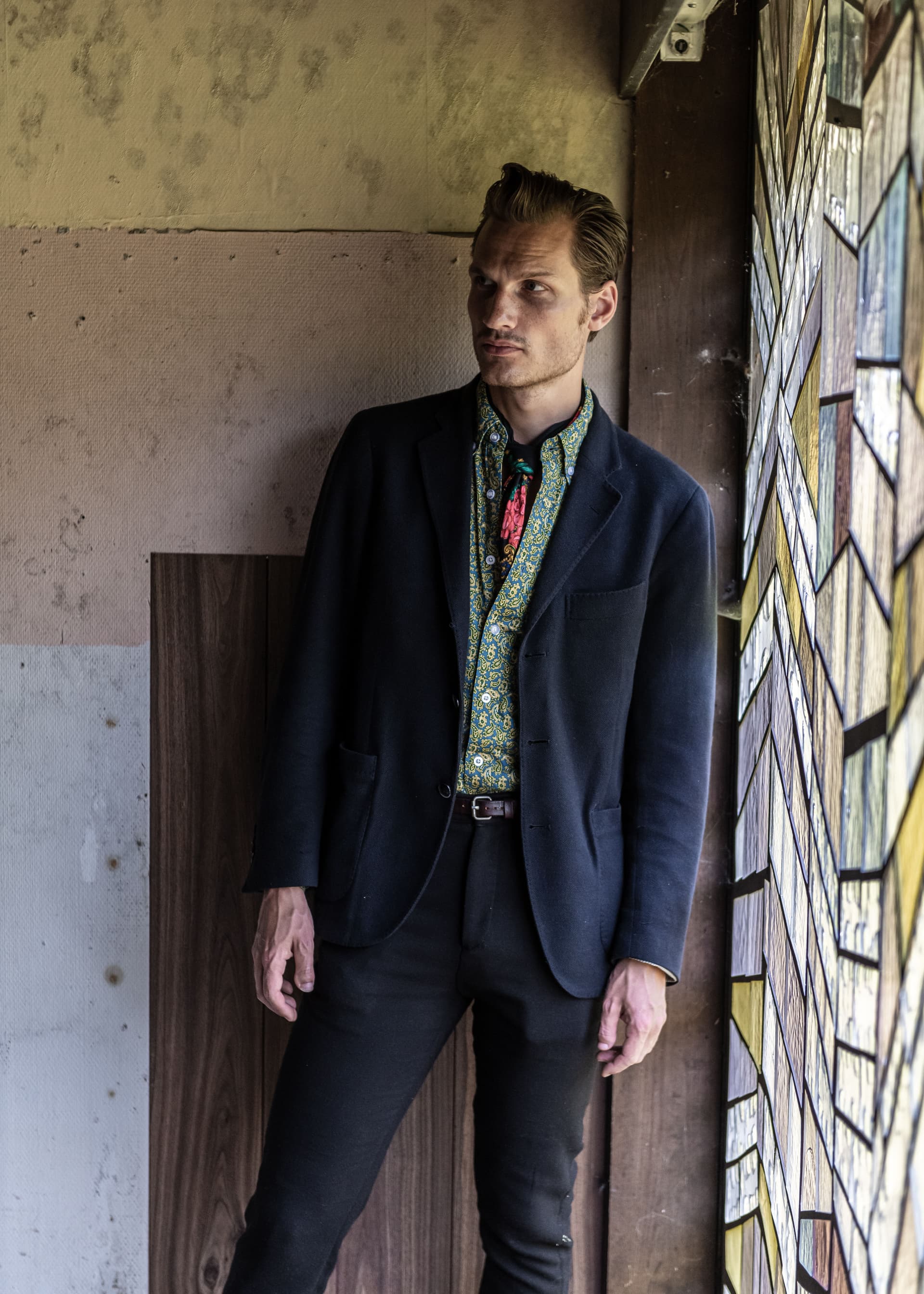 Halvkroppsporträtt på Bror Gunnar Jansson mot industrivägg inomhus