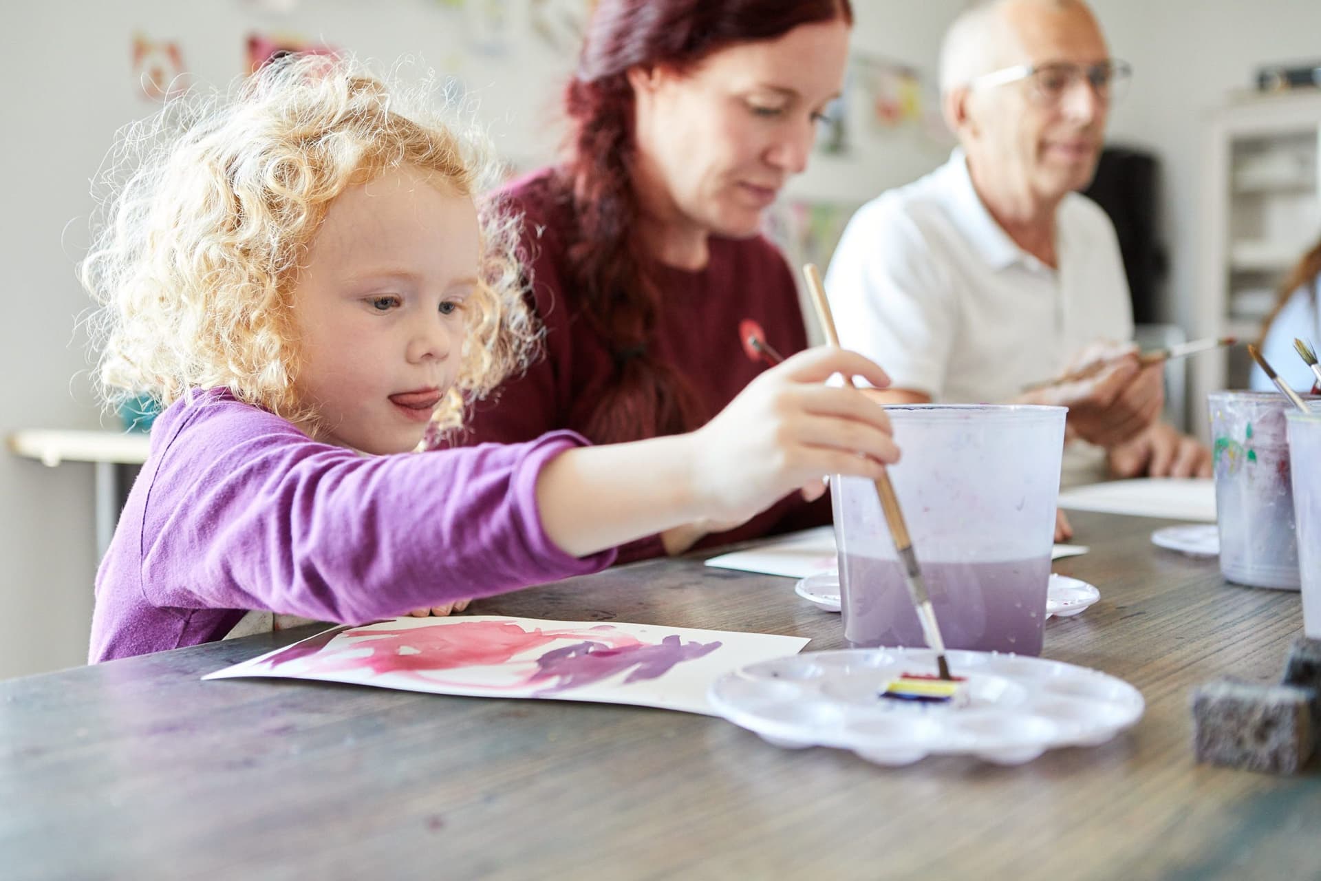 Vuxen och barn målar på en klippa